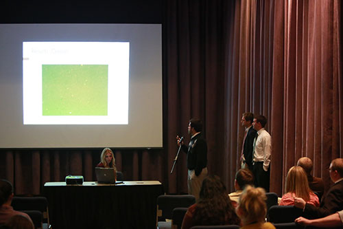 Four students in front of an audience presenting their research.