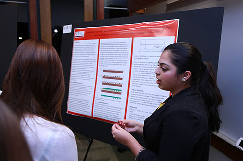 One student presenting information on her research poster.