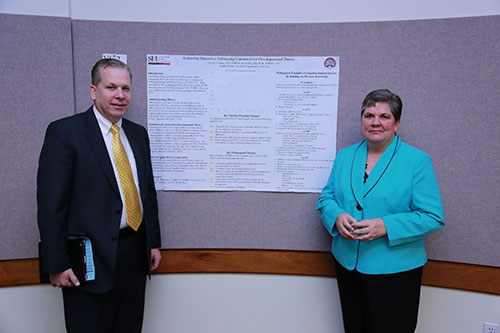 Alan Pearson and Donna Lister in front of an informative poster.