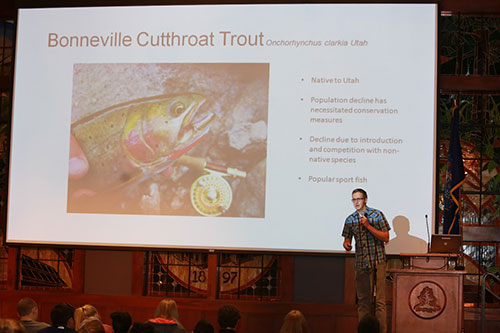 A male onstage presenting research on the Bonneville Cutthroat Trout.