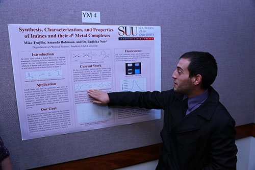 A male motioning to information on his poster.
