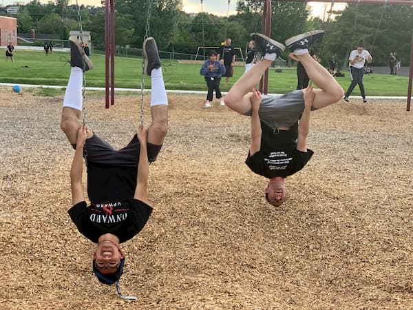 Upward Bound students hanging upside down on a playground