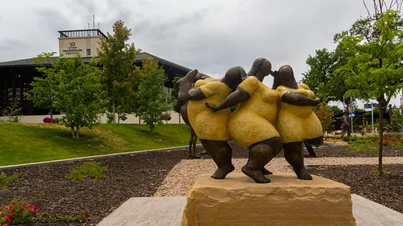 Photo of the Stillman Sculpture Court with the Engelstad Shakespeare Theatre in the background. Foreground is "Jubilation" by Nnamdi Okonkwo.