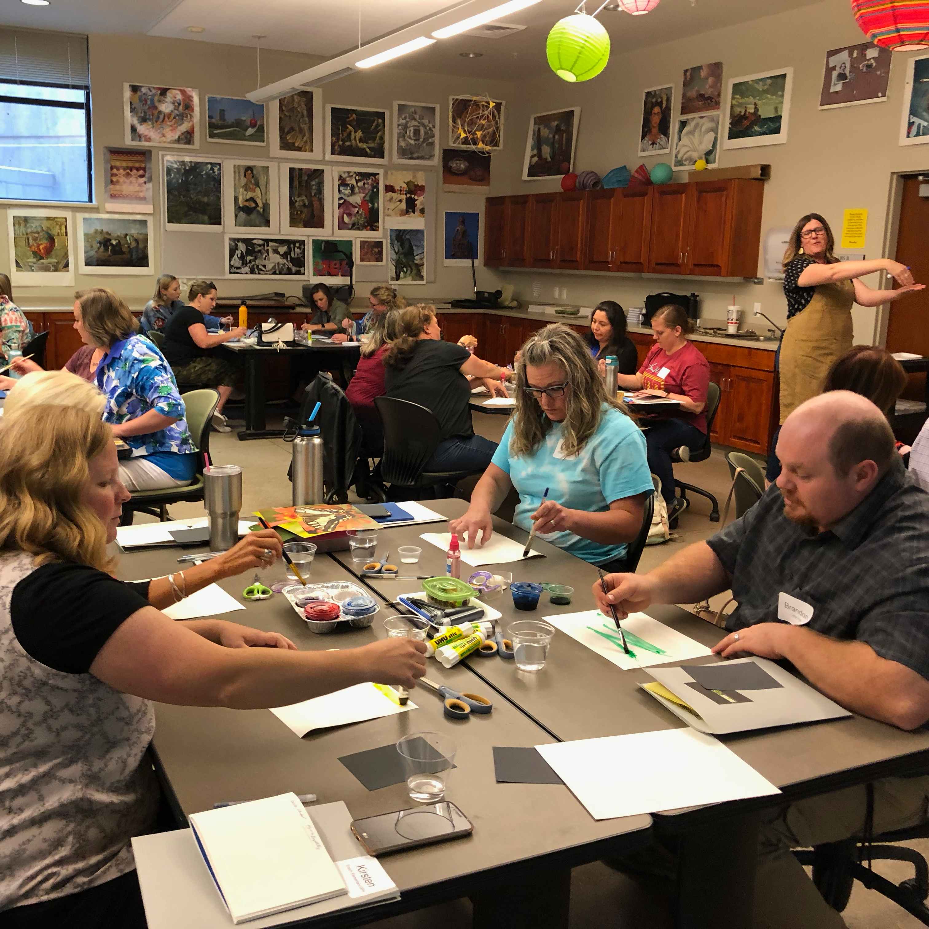 Educators painting with watercolors in a large group setting