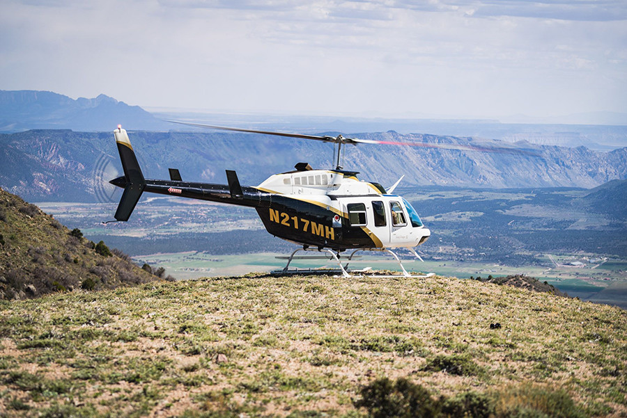 Picture of a Bell 206 helicopter on a peak.