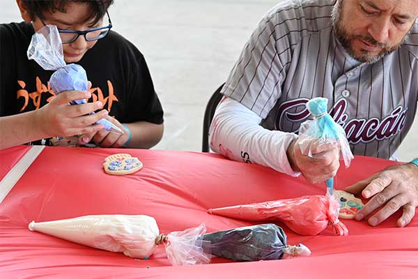 Father and Son decorating sugar skull cookies