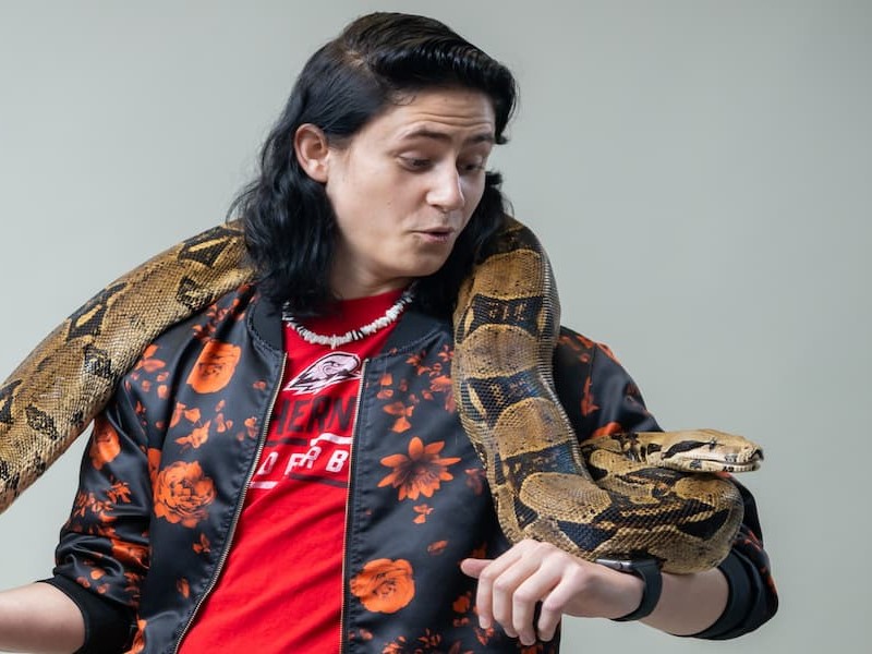Biology student holding a large python