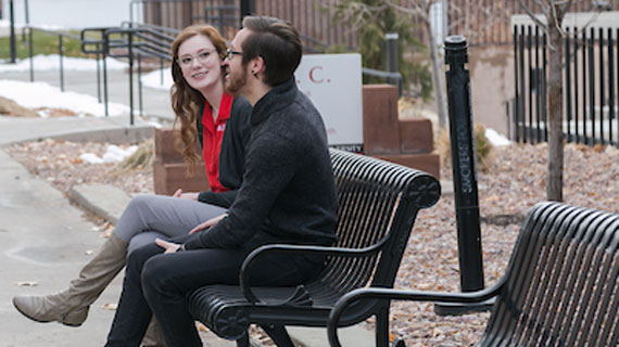 Students sitting on bench on campus