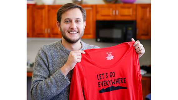 Student holding stenciled shirt