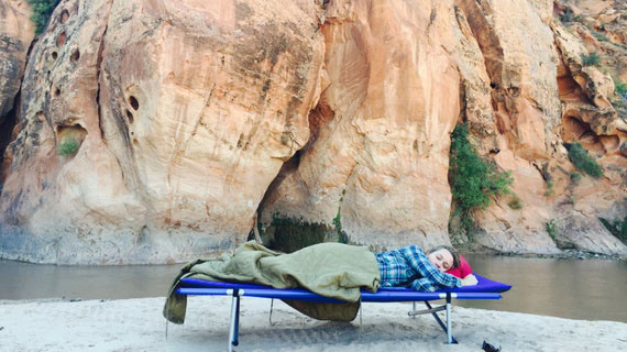 Person sleeping outside red cliffs