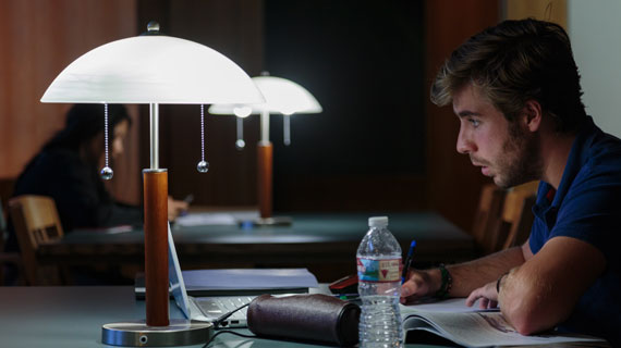 student studying under lamp