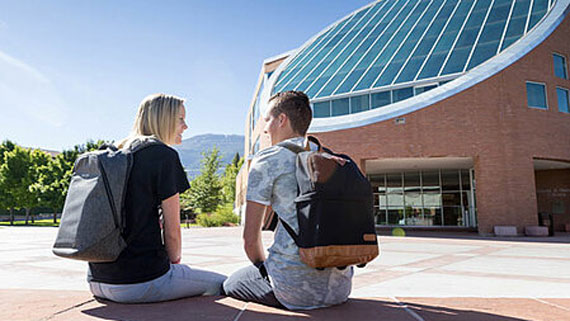 Two students talking outside of the library