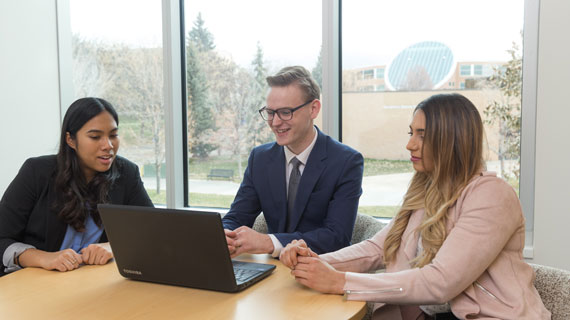 Business students next to a laptop