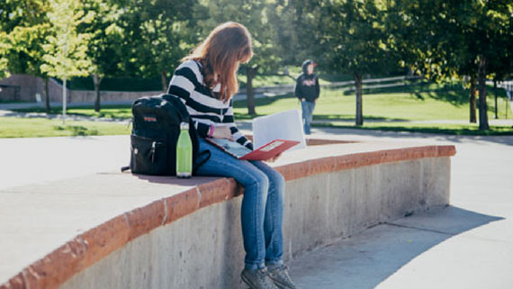 student looking at her laptop outdoors