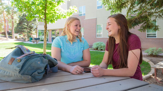 Two students outside laughing