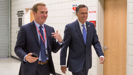 Mitt Romney walking down hall with student
