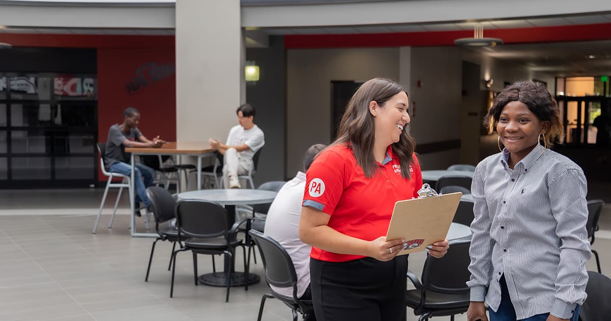 Two women talk together in the student center.