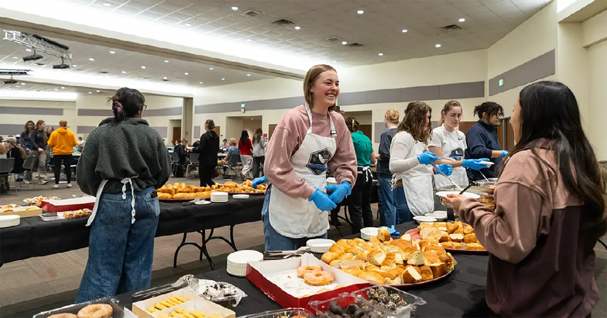 One student serves another at the Bread and Soup Night.