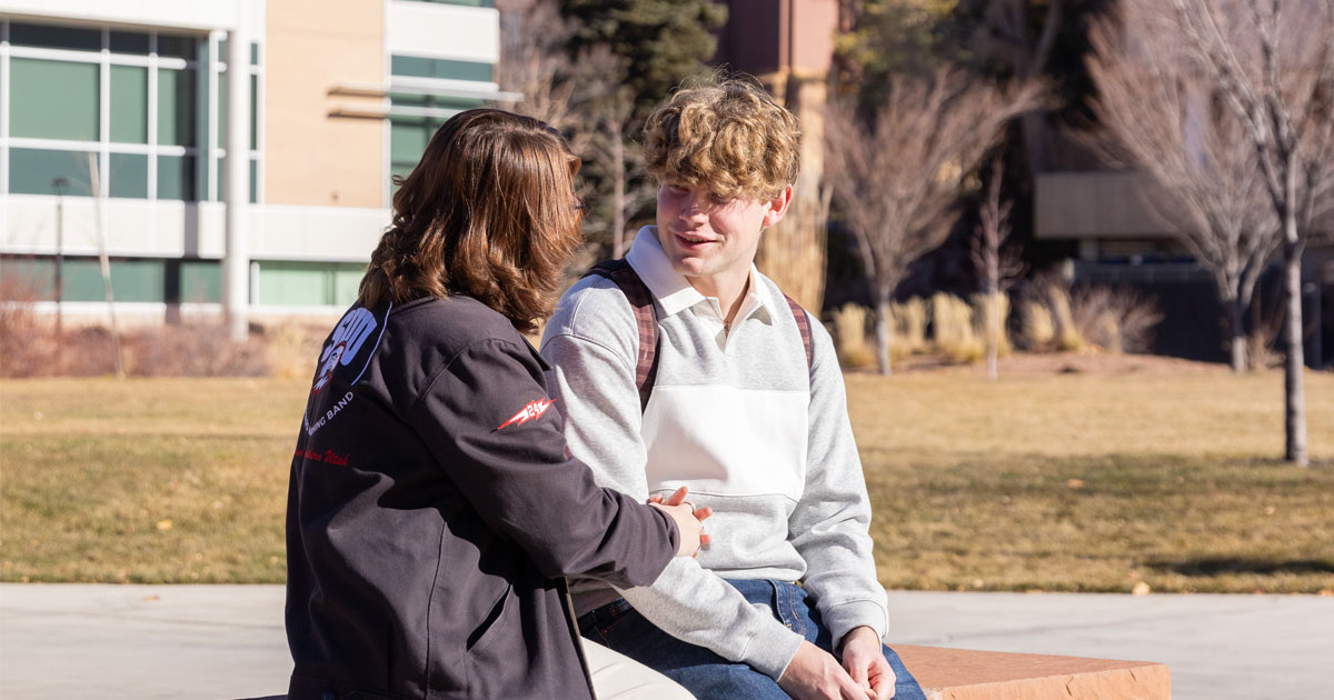 Two students sit outside at Southern Utah University