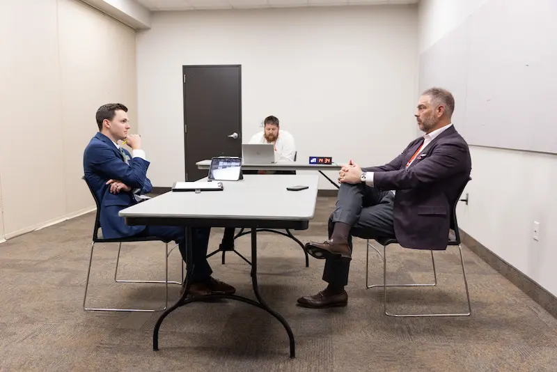 A man presenting to another man across a table 4