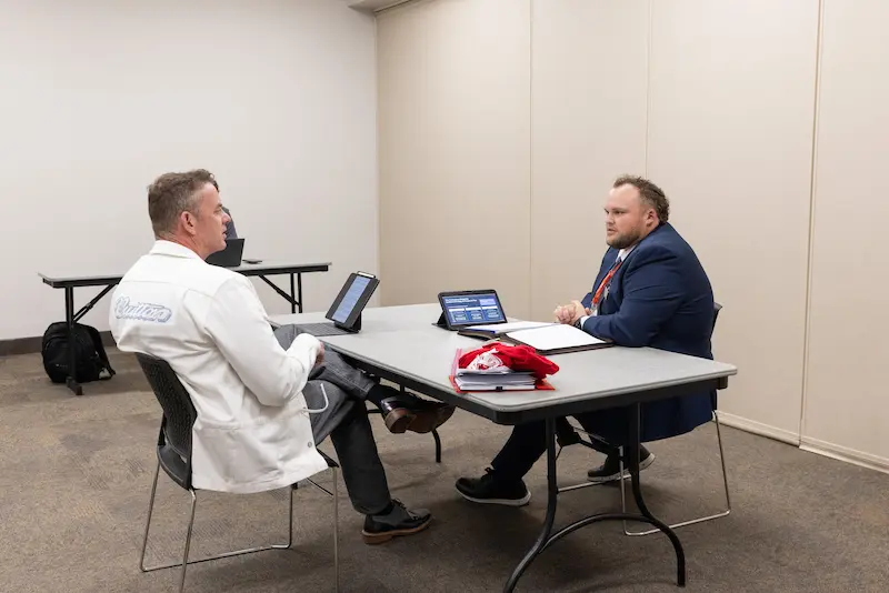 A man presenting to another man across a table 2 6