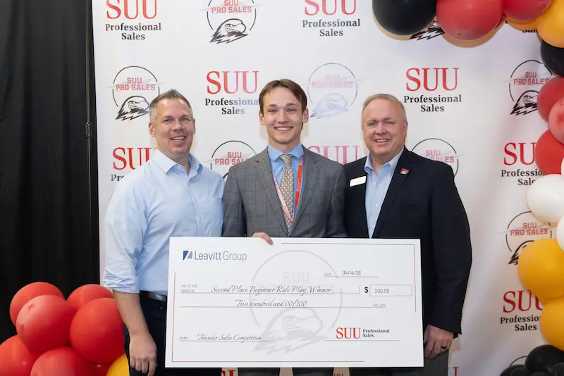 A student posing with check 3 18