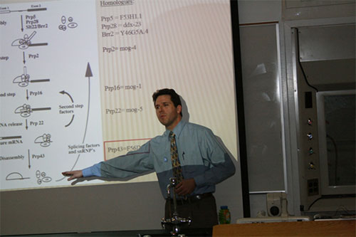 Dustin Langston pointing to information on one of his slides