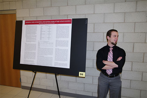 Beau Kunzler standing next to his research poster