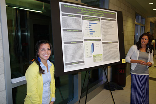 Two girls standing with their research poster