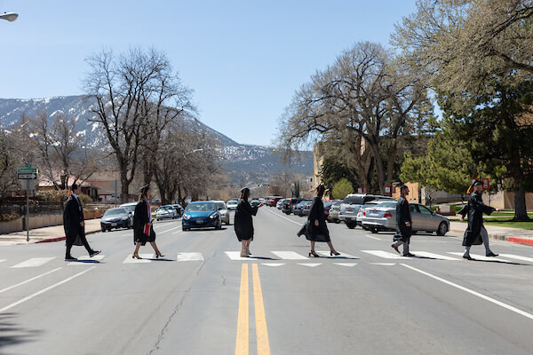 Five Graduates Crossing the Road at a Crosswalk