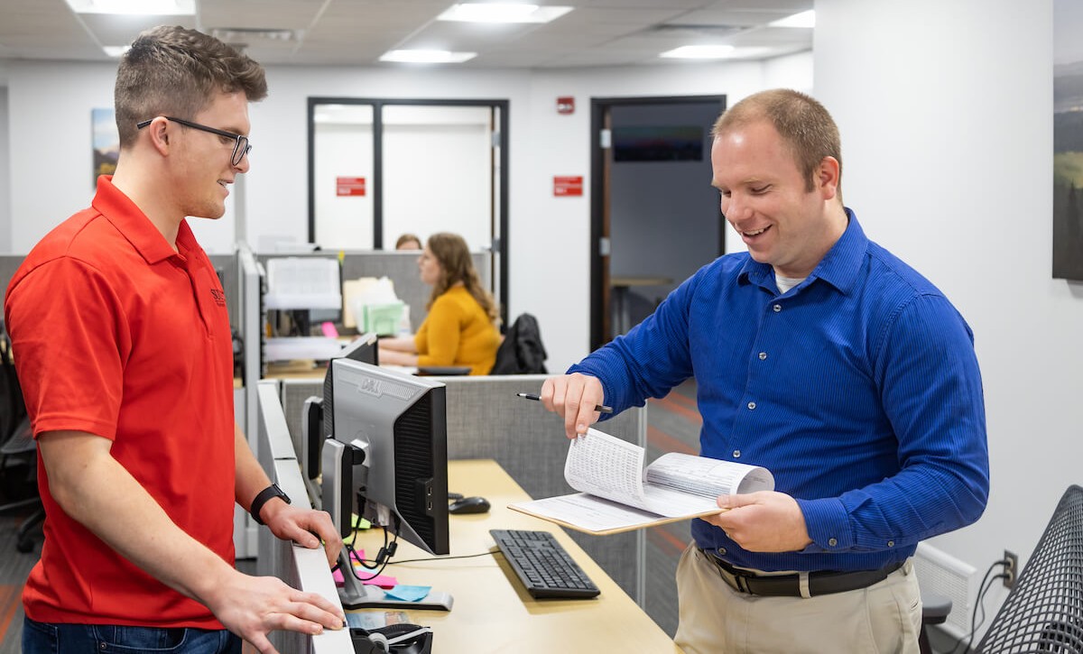 A young man talking across a desk from an HR advisor