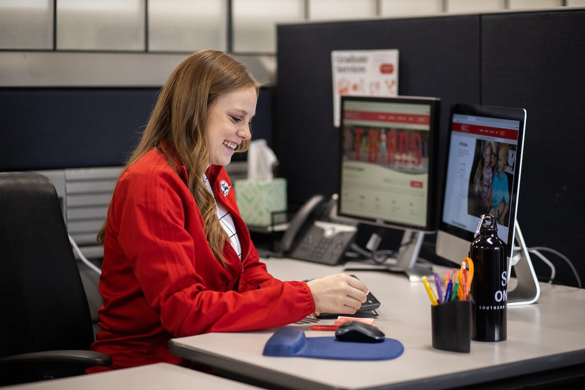 A woman sitting and working at a desk