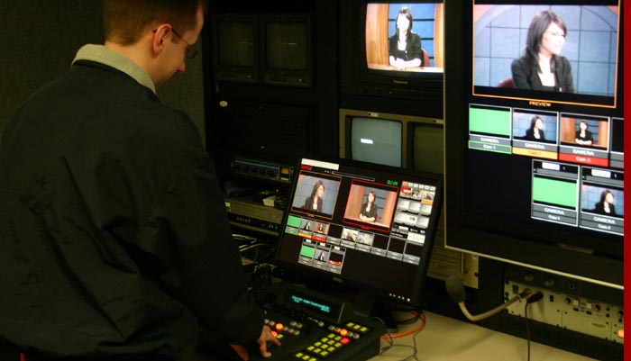 Photo of student running a video switcher in SUTV's control room.