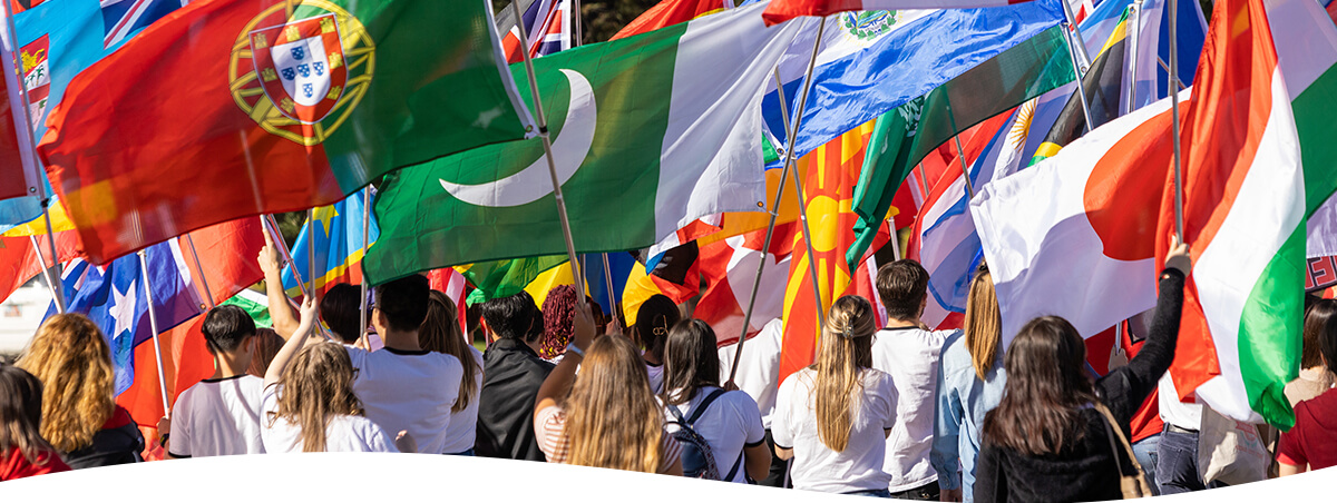 Students walking in parade with international flags