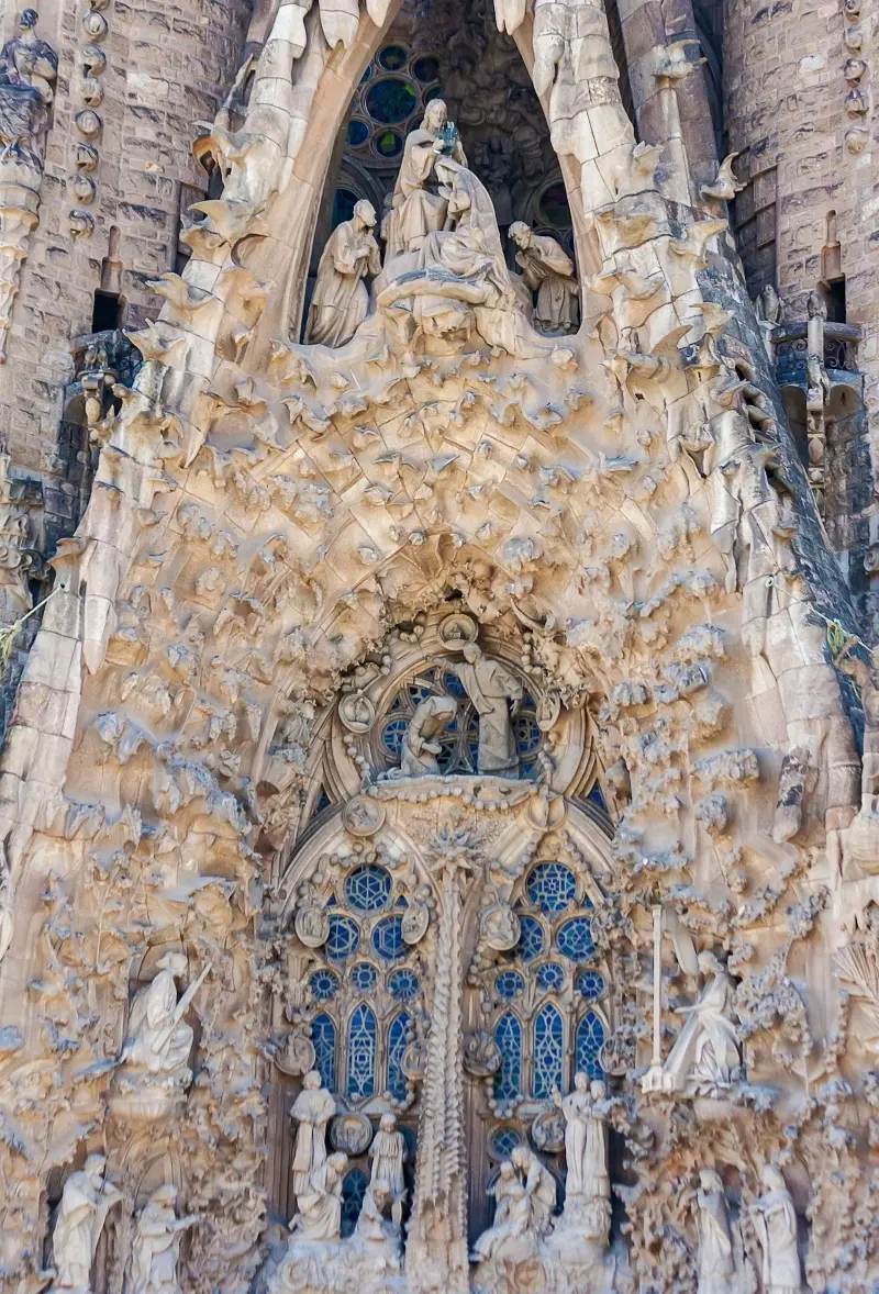 A close up photo of some of the incredibly intricate and beautifully crafted sculptures on the outside face of the Sagrada Familia. Dozens of sculpted figures in different poses adorn the alcove. 2