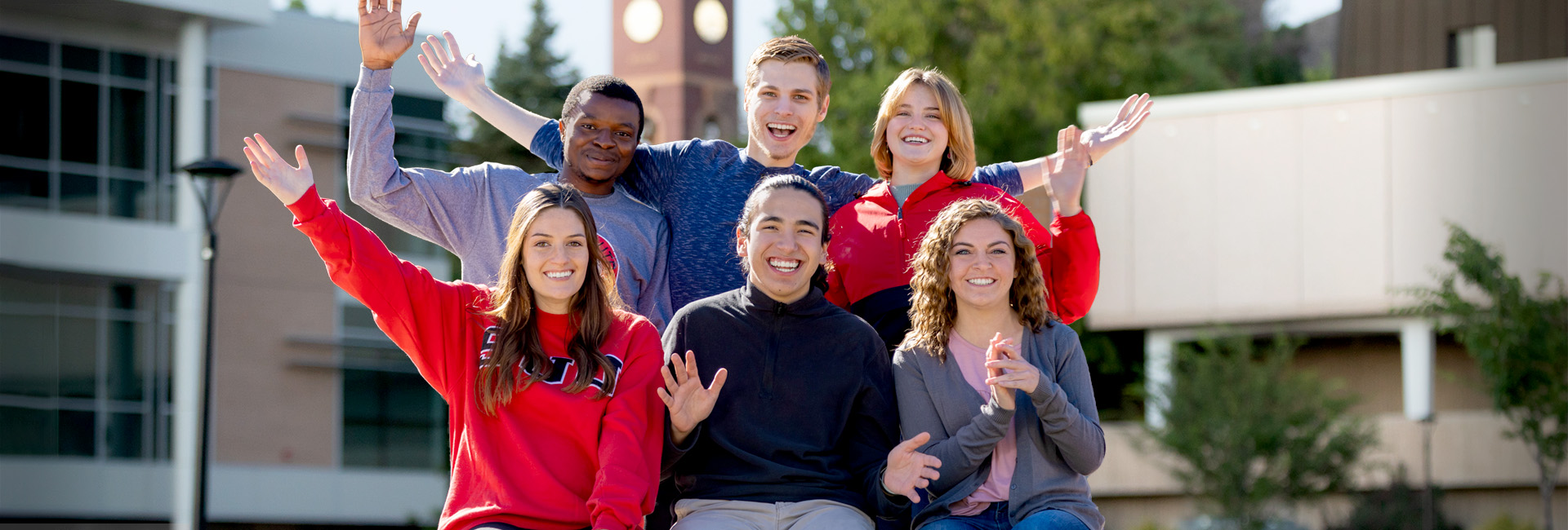 A Shot of six friends standing on campus in front of the clock tower.