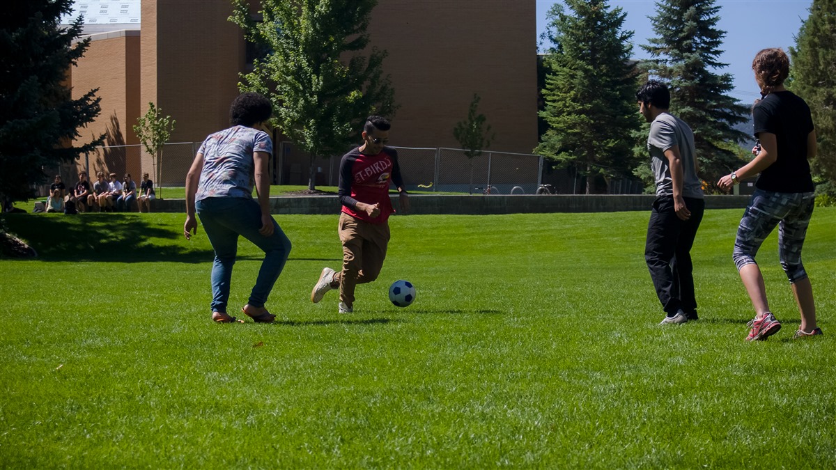 Students playing soccer on the grass 9