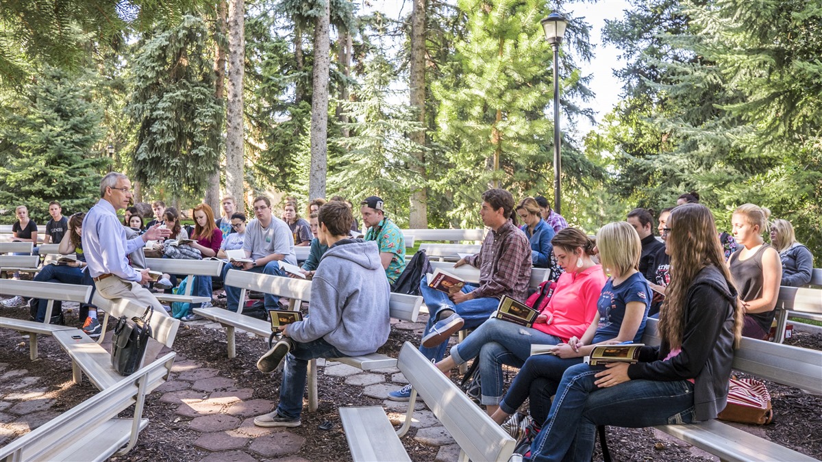 Students listening to an outdoor lecture from President Wyatt 11