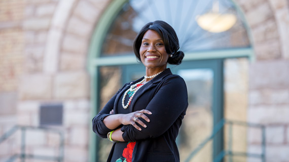 Schvalla Rivera, SUU's Chief Diversity Officer, posing in front of Old Main