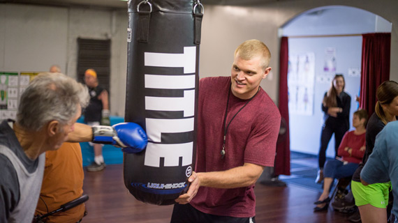 Rural Health Scholars student teaching man with Parkinson's Disease how to box