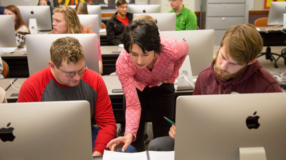 Professor with students at computers