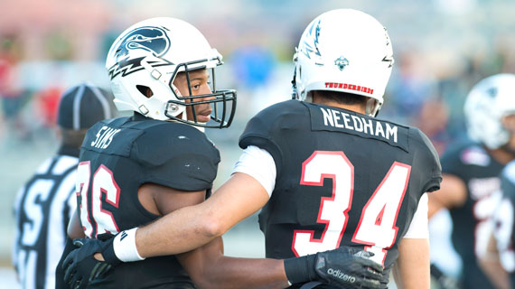 Mike Needham with Leshaun Sims, embracing on the football field