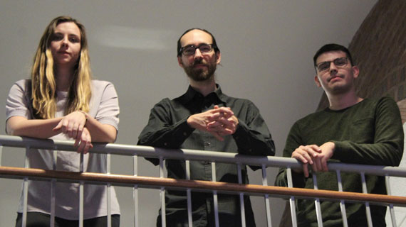 Members of the Wave Trio leaning over a banister