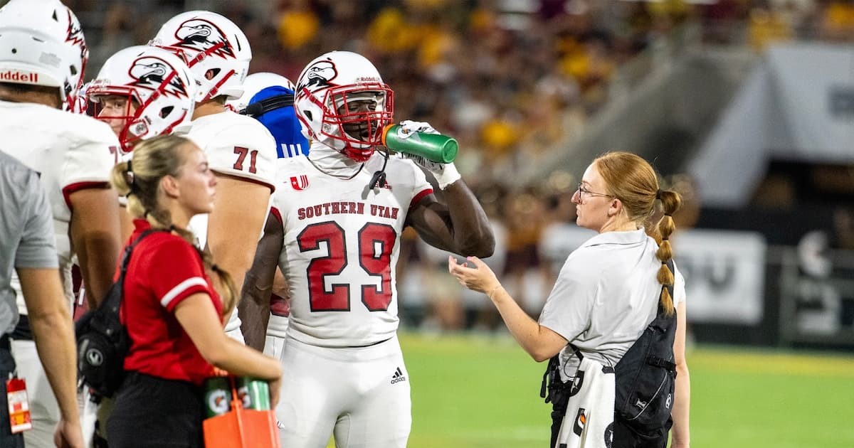 Trainer gives water to SUU football player at ASU game