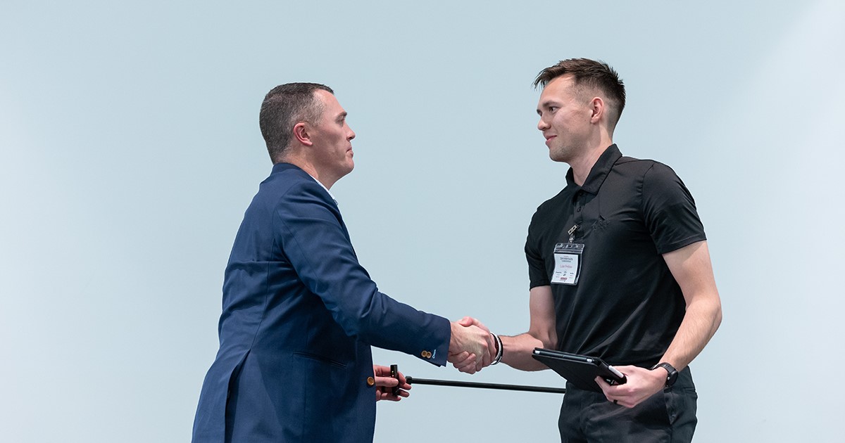 Sales student shakes hands with competition judge.