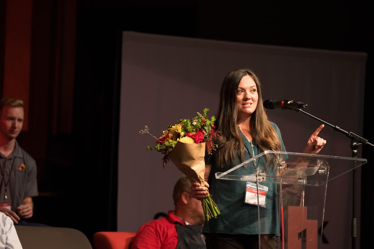 Finalist speaking while holding flowers