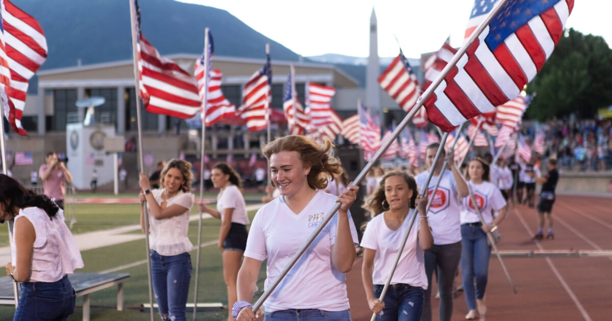 Girls carrying US Flags at Summer games opening ceremonies