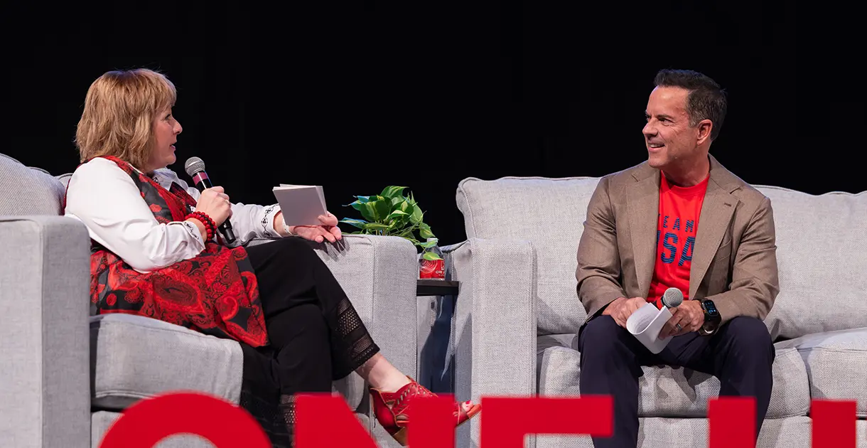 Two people sit on couches and discuss