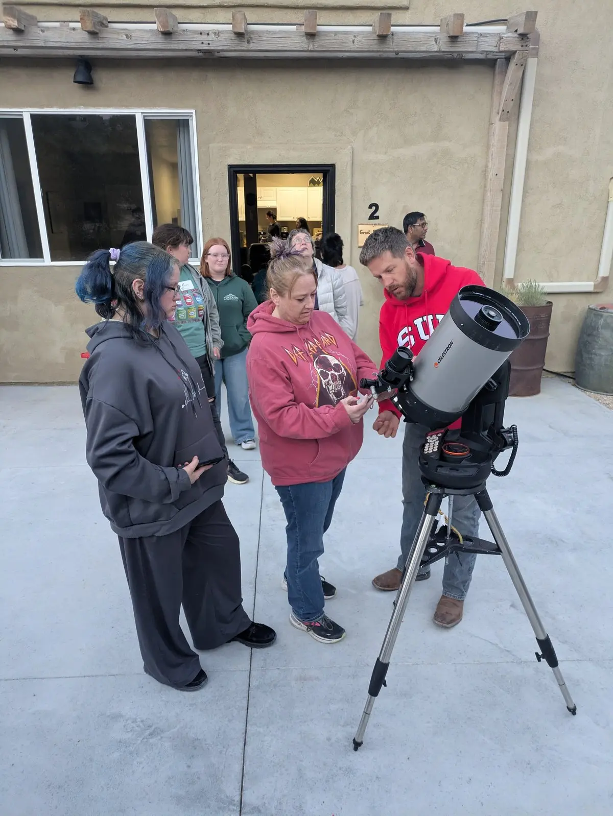 People gathered around a telescope