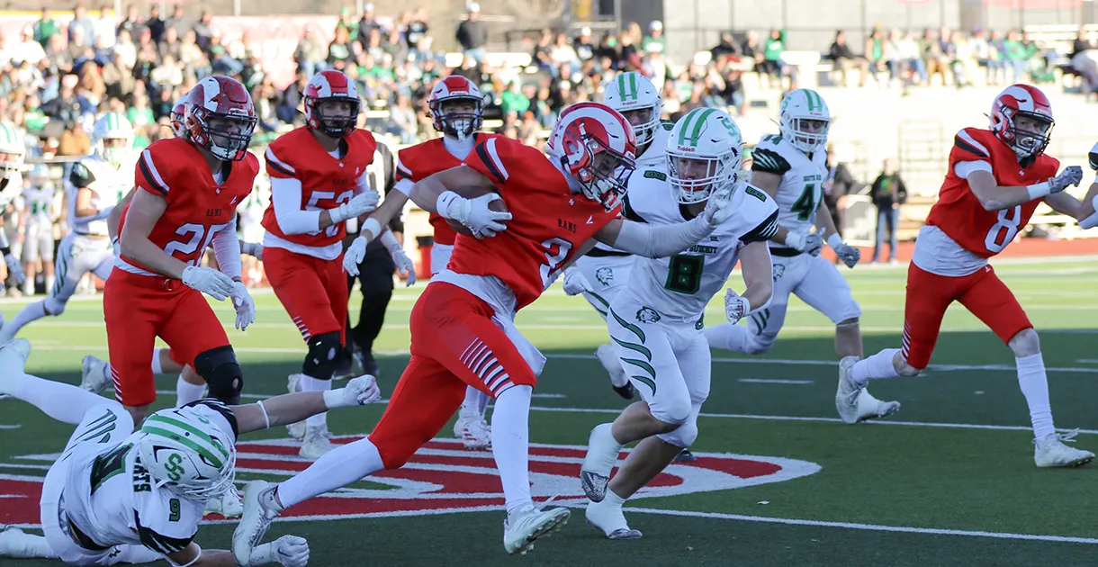 A football team runs across a football field